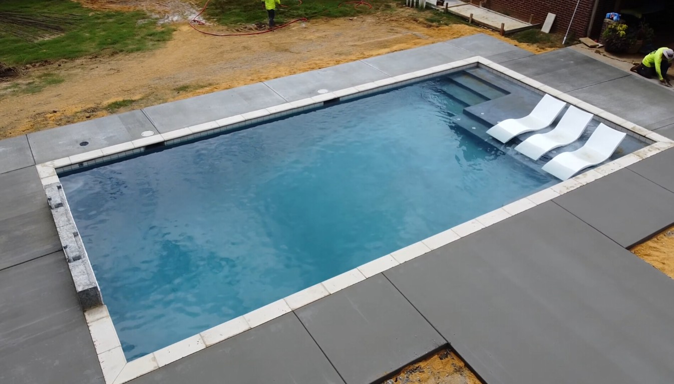 Freshly poured concrete pool deck surrounding residential swimming pool in Leavenworth, KS